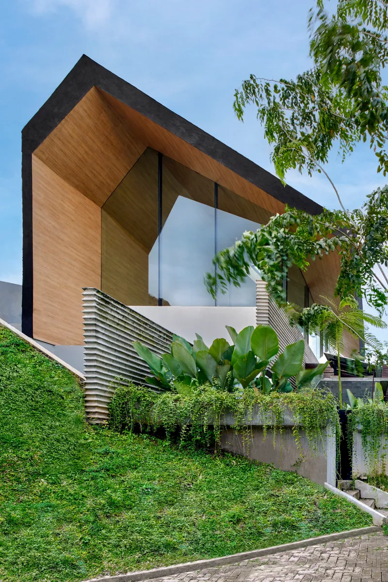 Planted green wall along the street edge with horizontal louvered screen and overhanging timber soffit above
