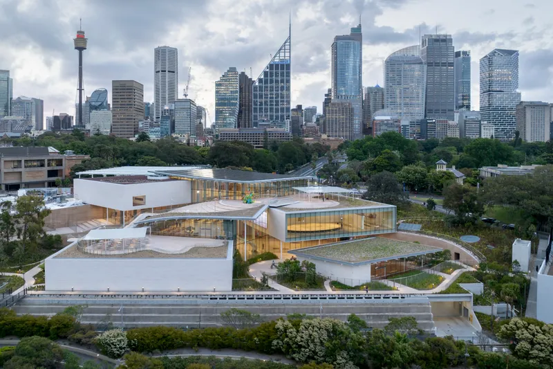 Elevated view showing the curving white roofs and glazed facades under overcast skies