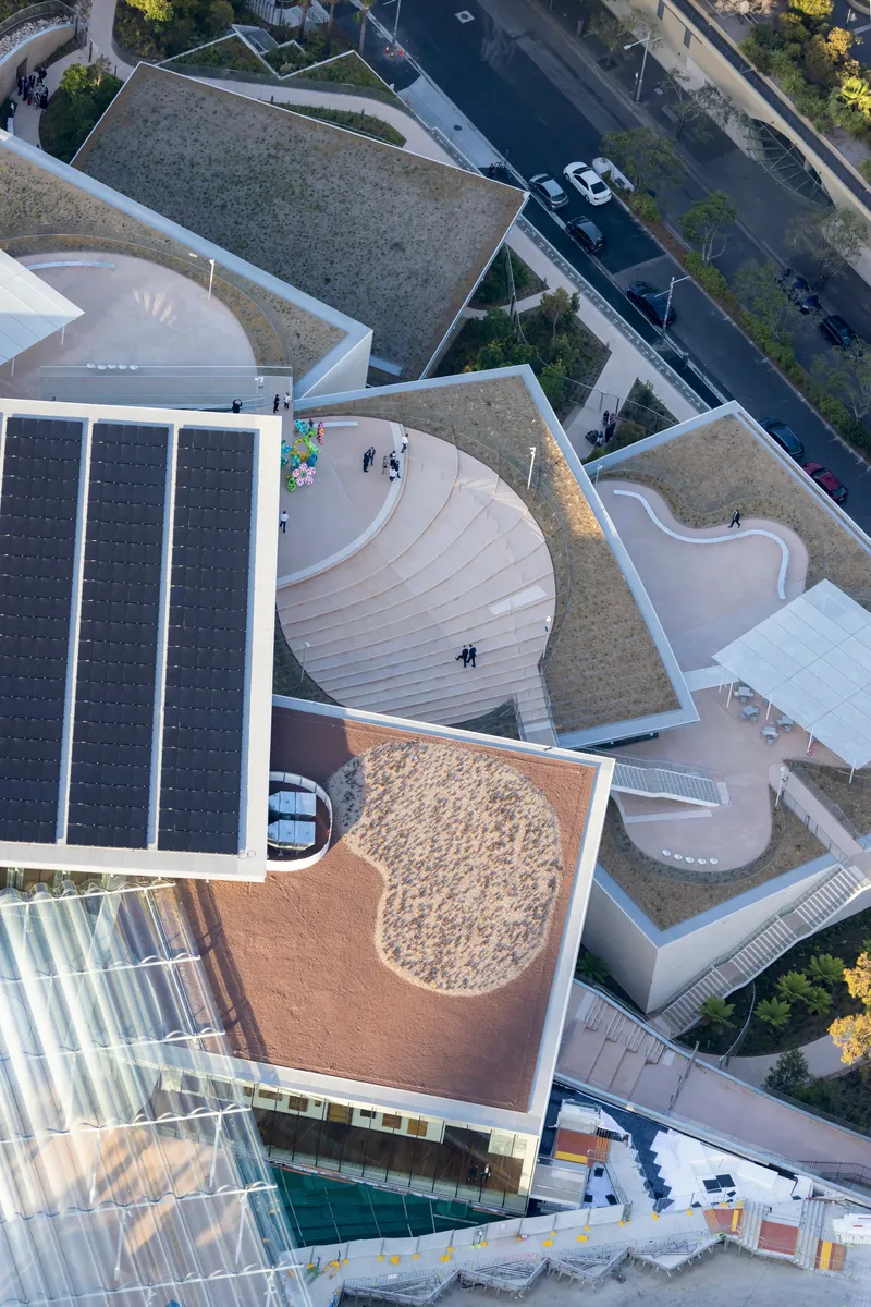 Overhead view of the curved terraces with planted roofs and circular amphitheater steps
