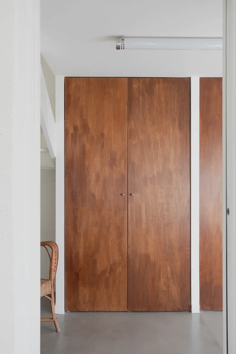 Timber double doors with white frame and sidelight panel opening to a polished concrete floor
