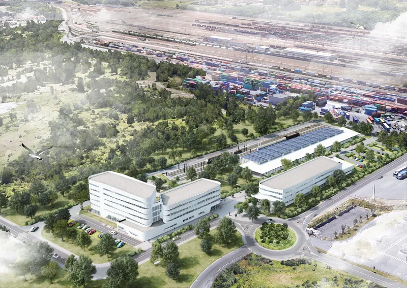 Aerial rendering of a campus with low-rise buildings, landscaped grounds, and rail yards in the distance
