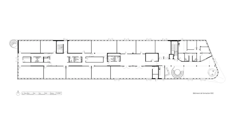Floor plan drawing depicting enclosed rooms along a linear corridor with circular elements at one end