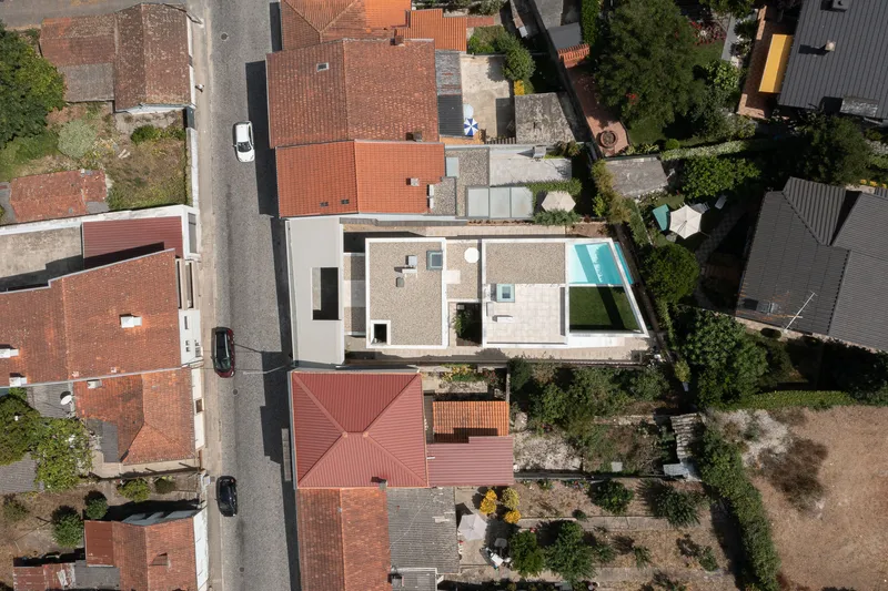 Aerial view showing rooftop courtyard with swimming pool surrounded by neighboring terracotta tiled roofs