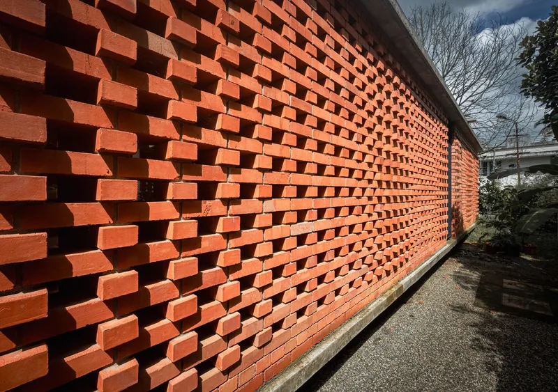 Close-up of the staggered brick screen wall with protruding units creating deep shadows