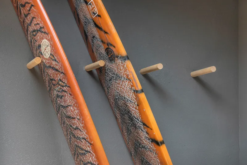 Timber handrails wrapped in textured rope alongside wooden pegs mounted on a grey wall
