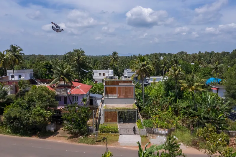 Aerial view of a residence with timber screens among palm trees and neighboring rooftops