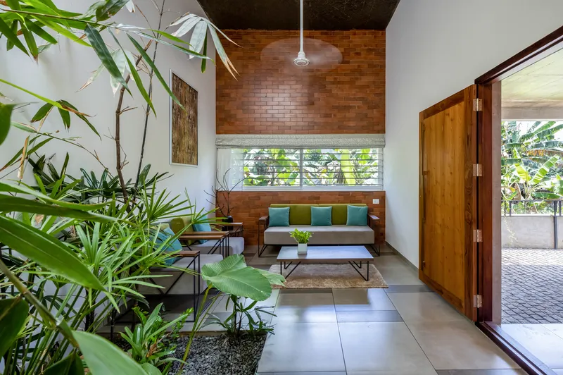 Living room with timber brick accent wall and interior bamboo planting beside large floor tiles