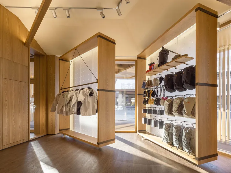 Interior retail space with timber display frames suspended from the ceiling beneath exposed timber beams