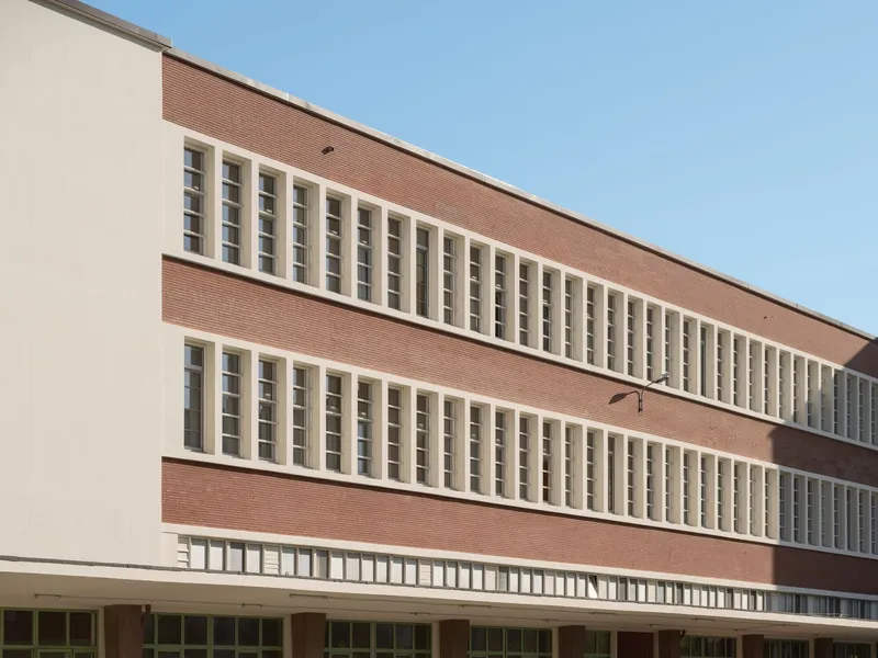 Facade detail showing alternating bands of brick and stucco with vertical window strips