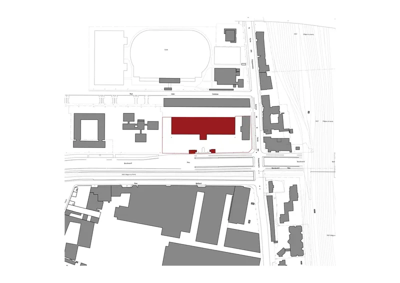 Site plan showing a red rectangular building footprint among grey structures and railway lines