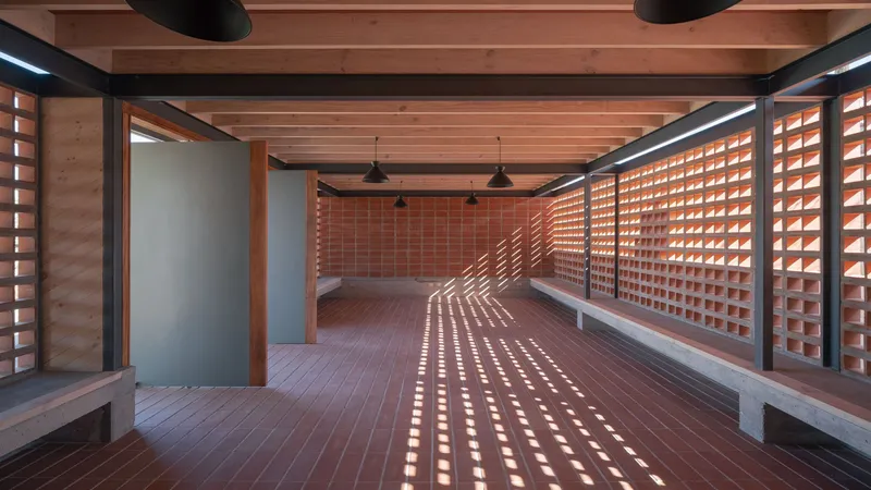Interior room with light filtering through perforated block walls onto clay tile flooring