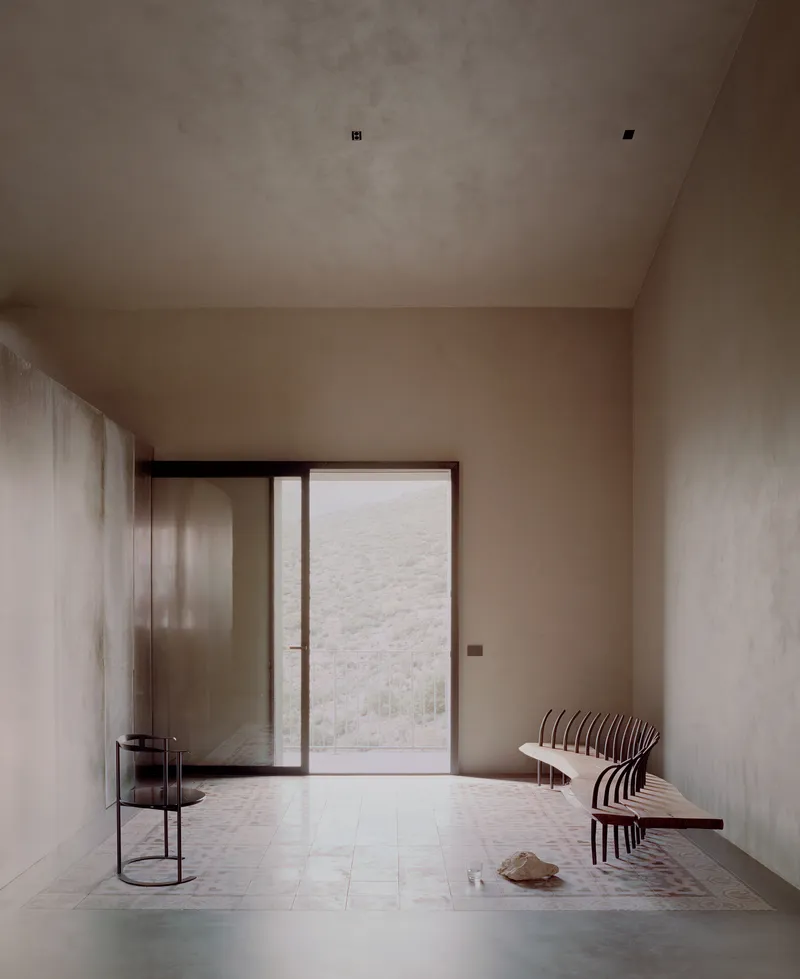 Foyer with glazed door looking onto a planted courtyard and slatted bench beside a steel plant stand