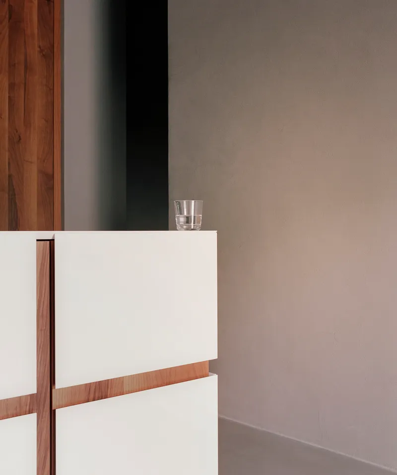 White and timber stair balustrade detail with a glass of water on the edge