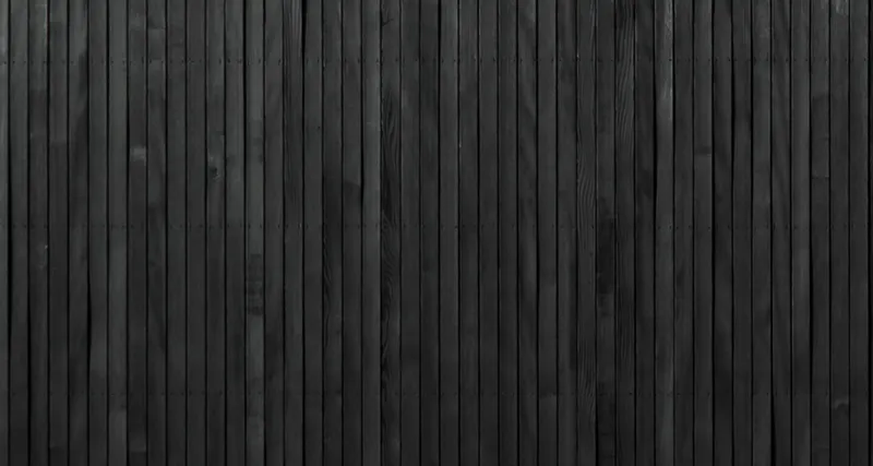 Close-up of vertical blackened timber cladding with fine parallel grooves