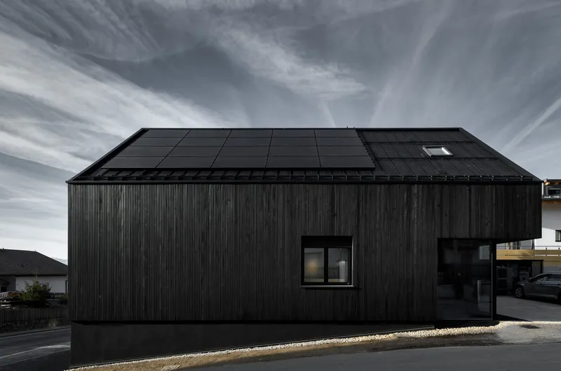 Solar panel array integrated into the pitched roof with photovoltaic modules and a single skylight opening