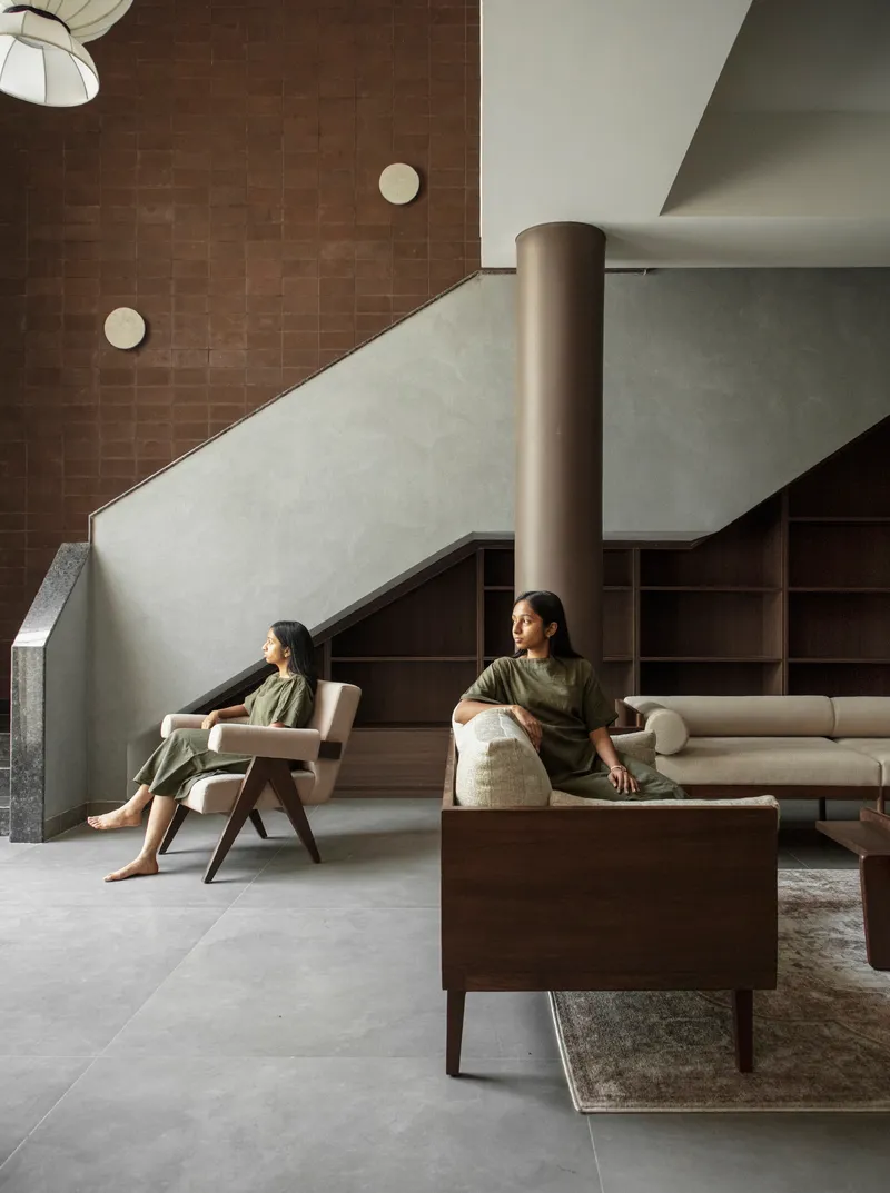 Interior view showing staircase with plaster balustrade and two figures seated in the lounge below