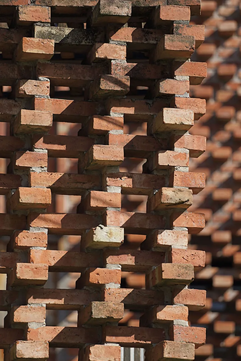 Close-up of staggered brick coursing creating a textured screen wall in afternoon light