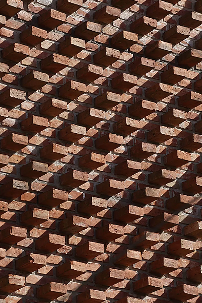 Detail of diagonal brick pattern with deep shadows cast by projecting units