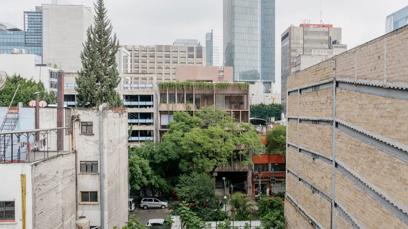View of the planted facade with rooftop garden and high-rises in the surrounding urban context