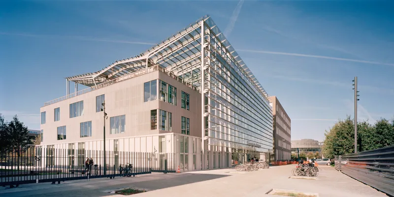 Street view of the metal panel facade with glass louver roof structure visible above