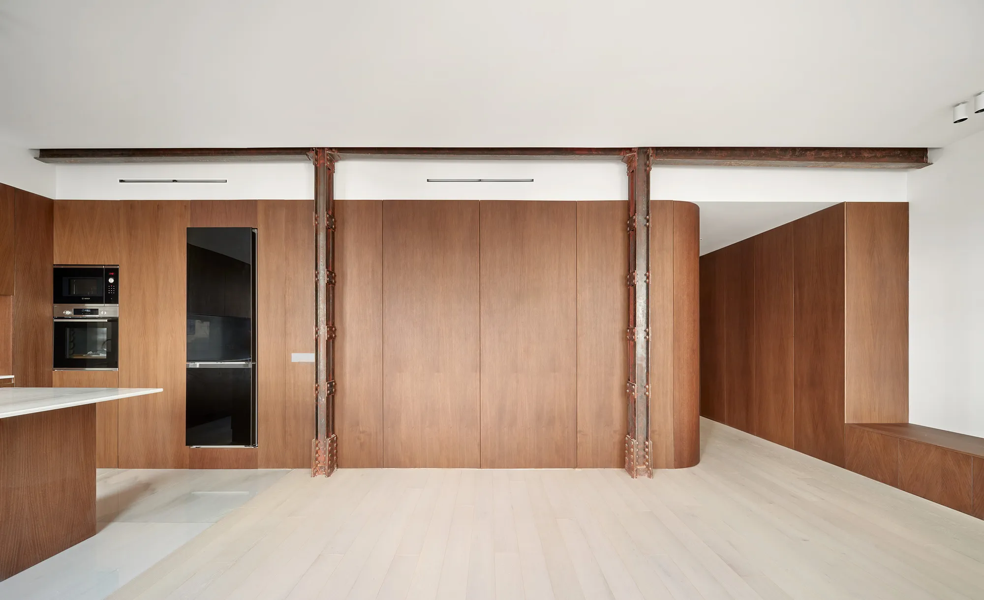 Pulso Arquitectos Carves a Madrid Apartment Around Exposed Steel Columns and Walnut Millwork