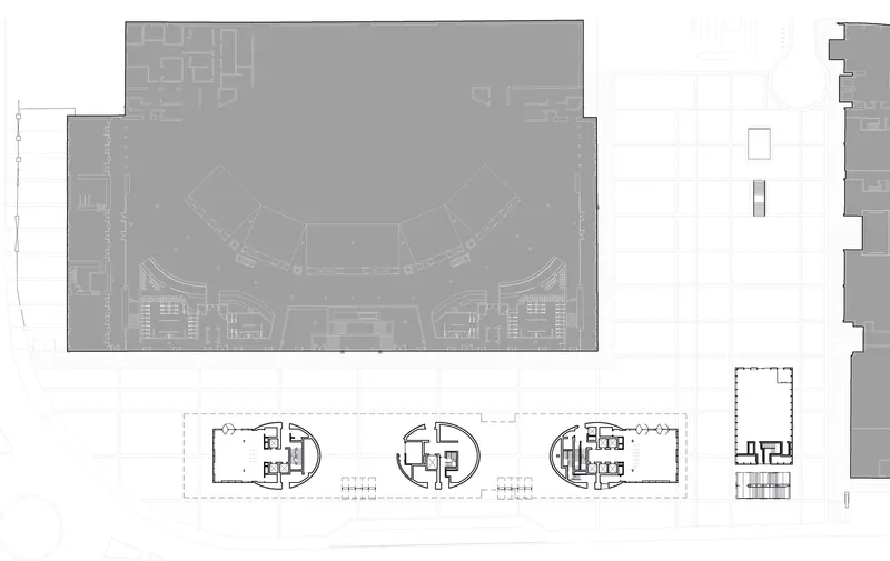 Floor plan drawing showing a curved atrium space above a ground floor with service cores