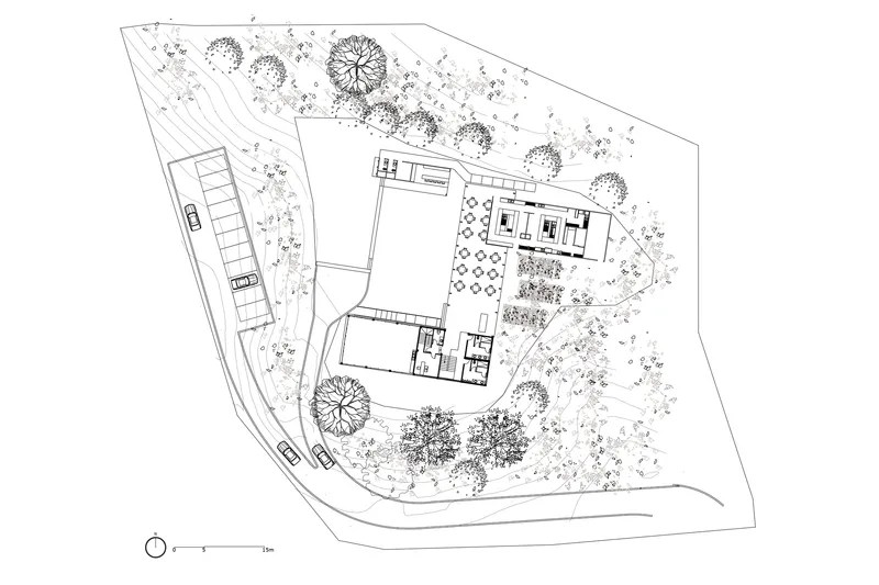 Site plan drawing showing building volumes and landscape with trees and parking areas