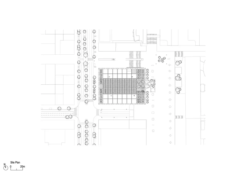 Site plan drawing showing a rectangular building footprint surrounded by landscaped areas and street trees
