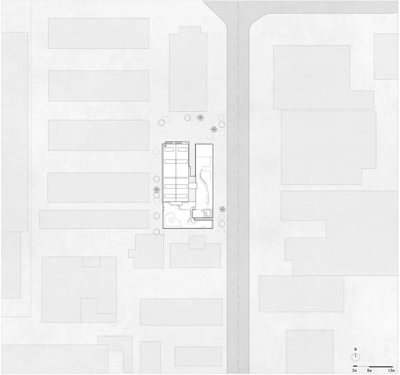 Site plan drawing showing the building footprint positioned among surrounding urban blocks and street trees