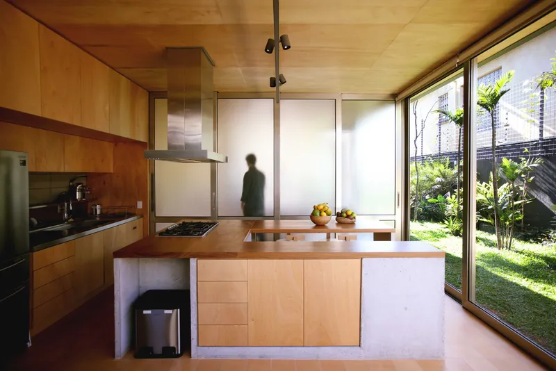 Kitchen island with stainless steel hood and translucent sliding panels overlooking a courtyard garden