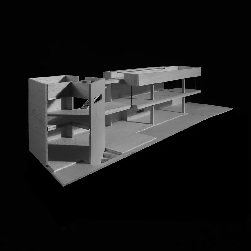 Physical model in perspective revealing stacked floor plates and open-air circulation between volumes