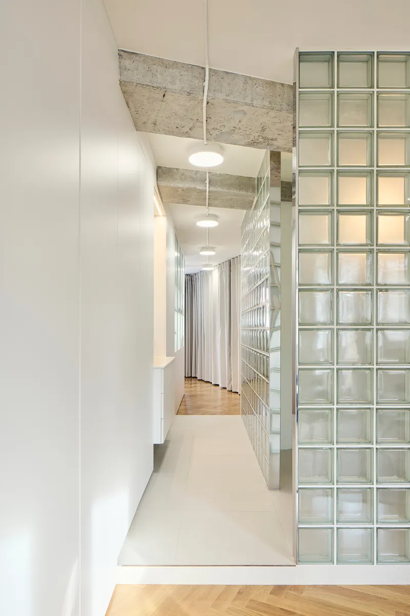 Corridor detail with glass block wall and view through to herringbone parquet flooring