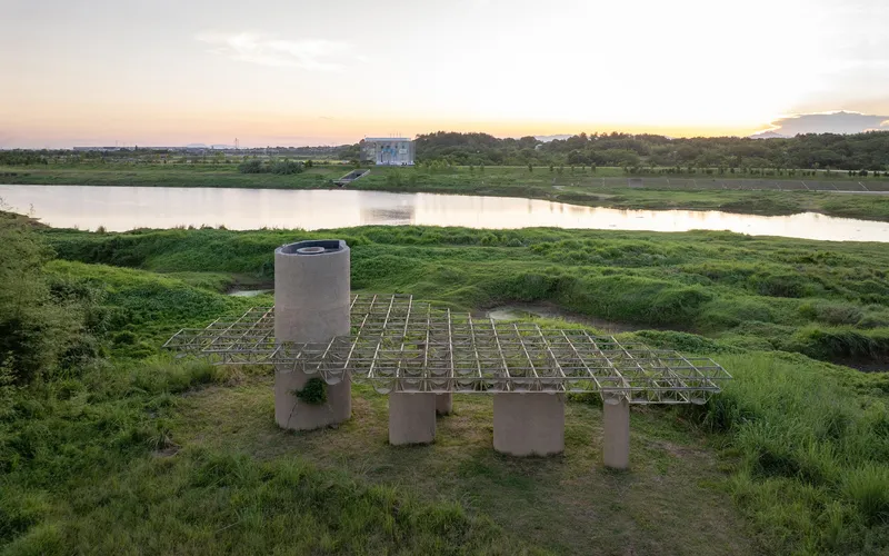 Elevated platform on concrete piers overlooking a river and wetlands at dusk with pink horizon light