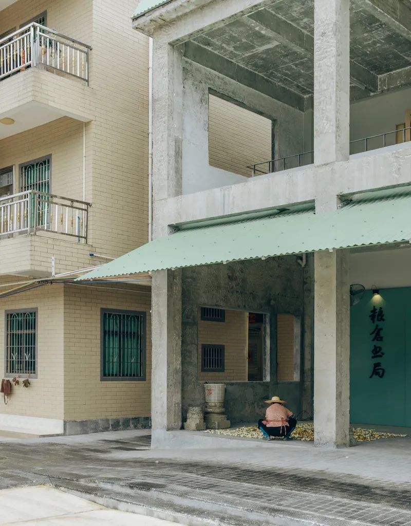 View through concrete portico to adjacent residential buildings with tile cladding and metal railings