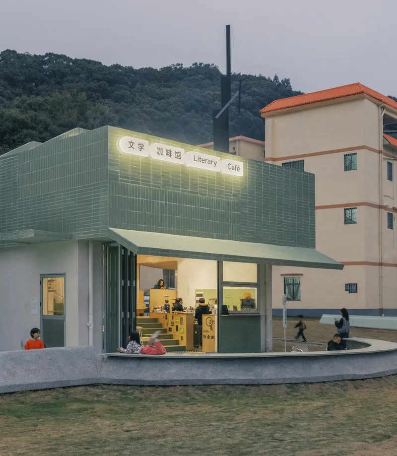 Corner view of the pavilion with ceramic tile roof and illuminated signage at dusk