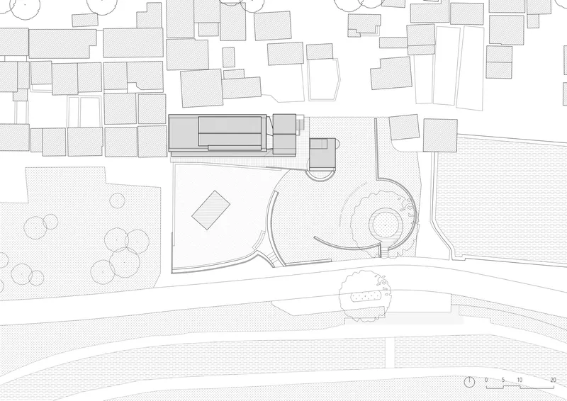 Site plan drawing showing the pavilion nestled between existing buildings and a curved waterfront edge