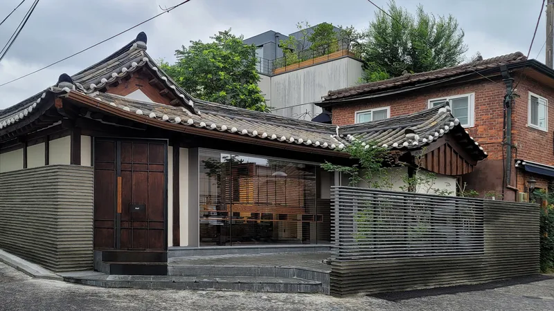 Street view of the entry facade with horizontal ribbed metal cladding and curved tile roof