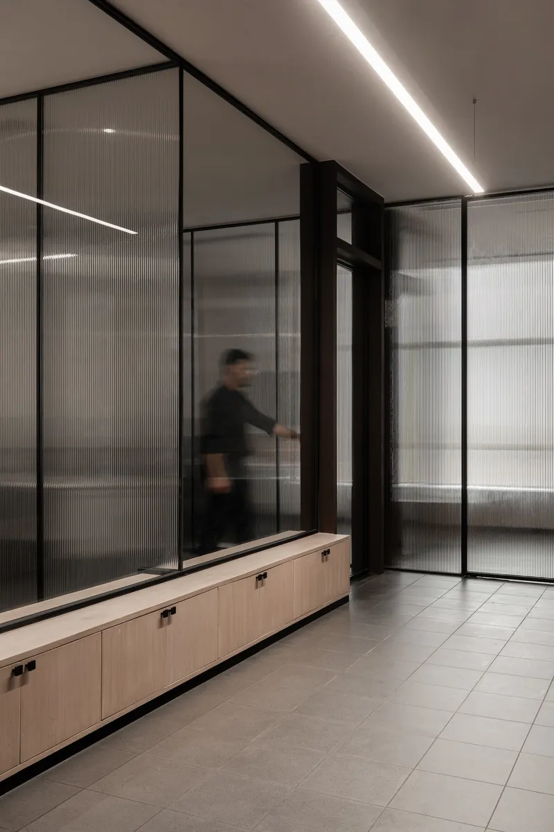Corridor with translucent glass partitions and a person in motion captured with blur