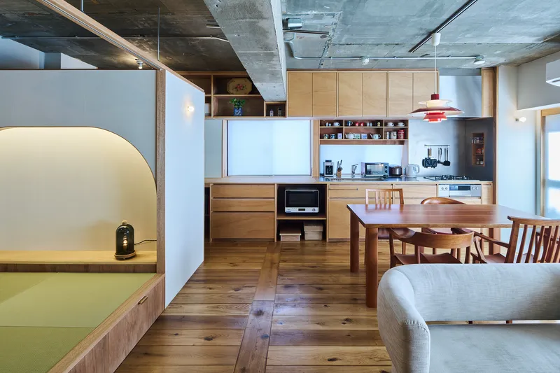 Kitchen and dining area with timber cabinetry and arched opening to tatami platform