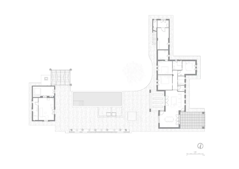 Floor plan drawing depicting L-shaped volumes connected by a central courtyard and pool