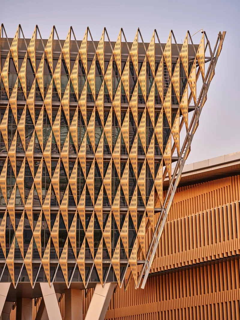 Close-up of the repeating timber brise-soleil with diamond module pattern in golden hour sun