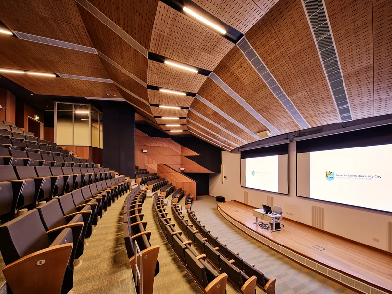 Auditorium interior with tiered seating and woven timber ceiling panels with integrated linear lighting