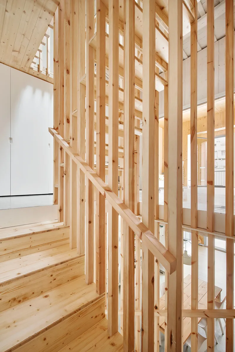 Vertical timber slat screen framing the staircase with natural light filtering through the openings