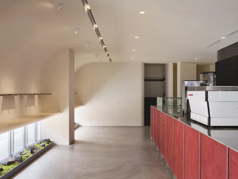 Curved balcony edge overlooking a service counter with red panels and espresso machine