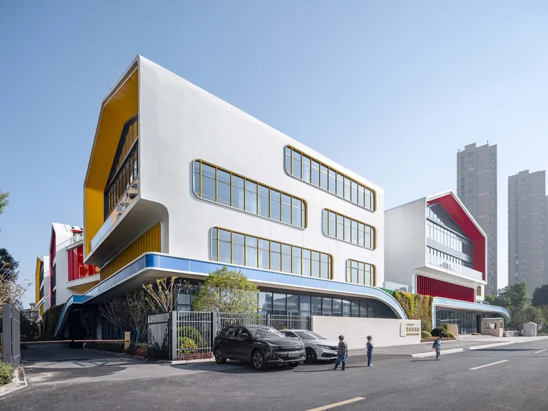 Street-level view of the white facades with horizontal ribbon windows and colorful red and yellow panels