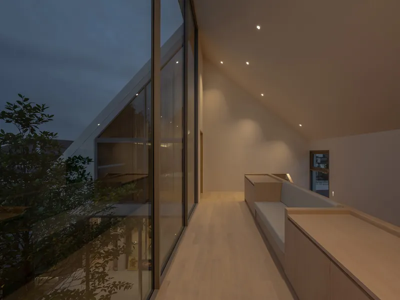 Upper-level hallway with sloped glass wall overlooking an interior courtyard with trees at twilight