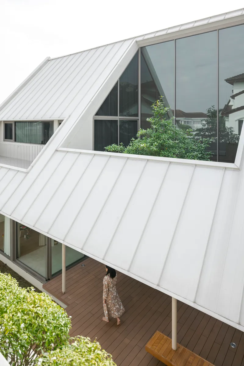 Elevated view of timber deck walkway with resident below and white metal canopy above