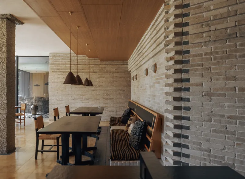 Dining space with striped brick wall and timber-framed shoji screens under a wood ceiling