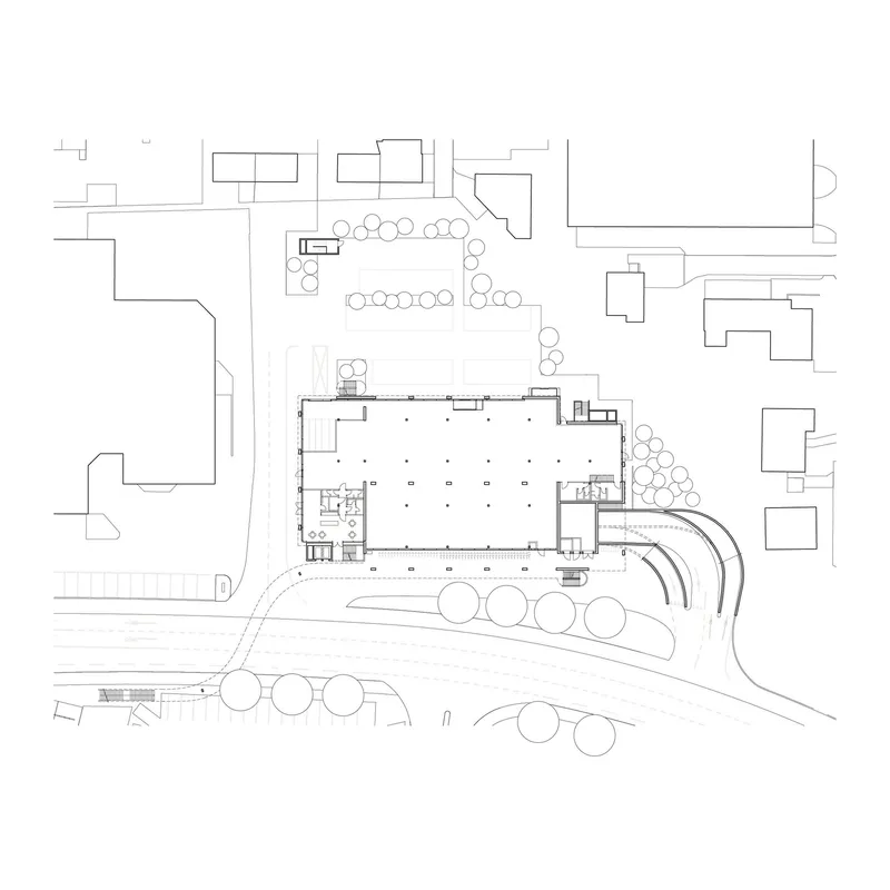 Site plan drawing showing the building footprint surrounded by street trees and adjacent structures