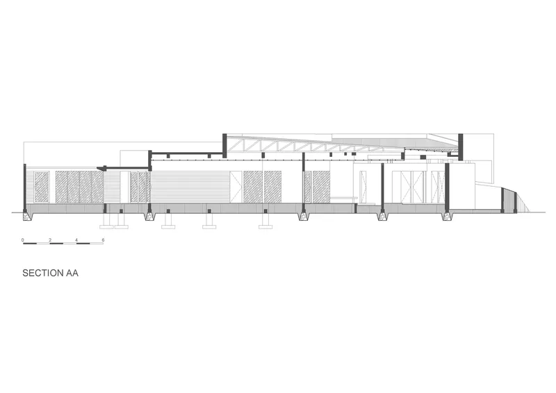 Section drawing showing the single-story structure with exposed roof trusses and column supports